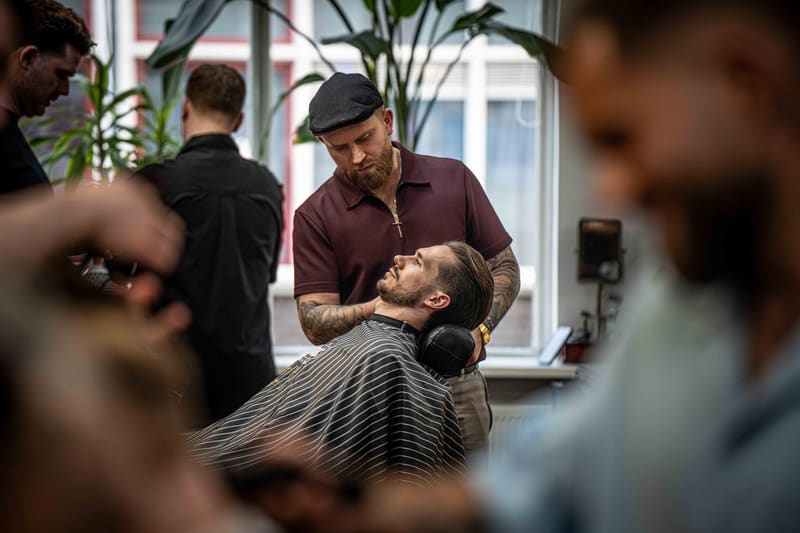 Barbero revisando un corte con su cliente
